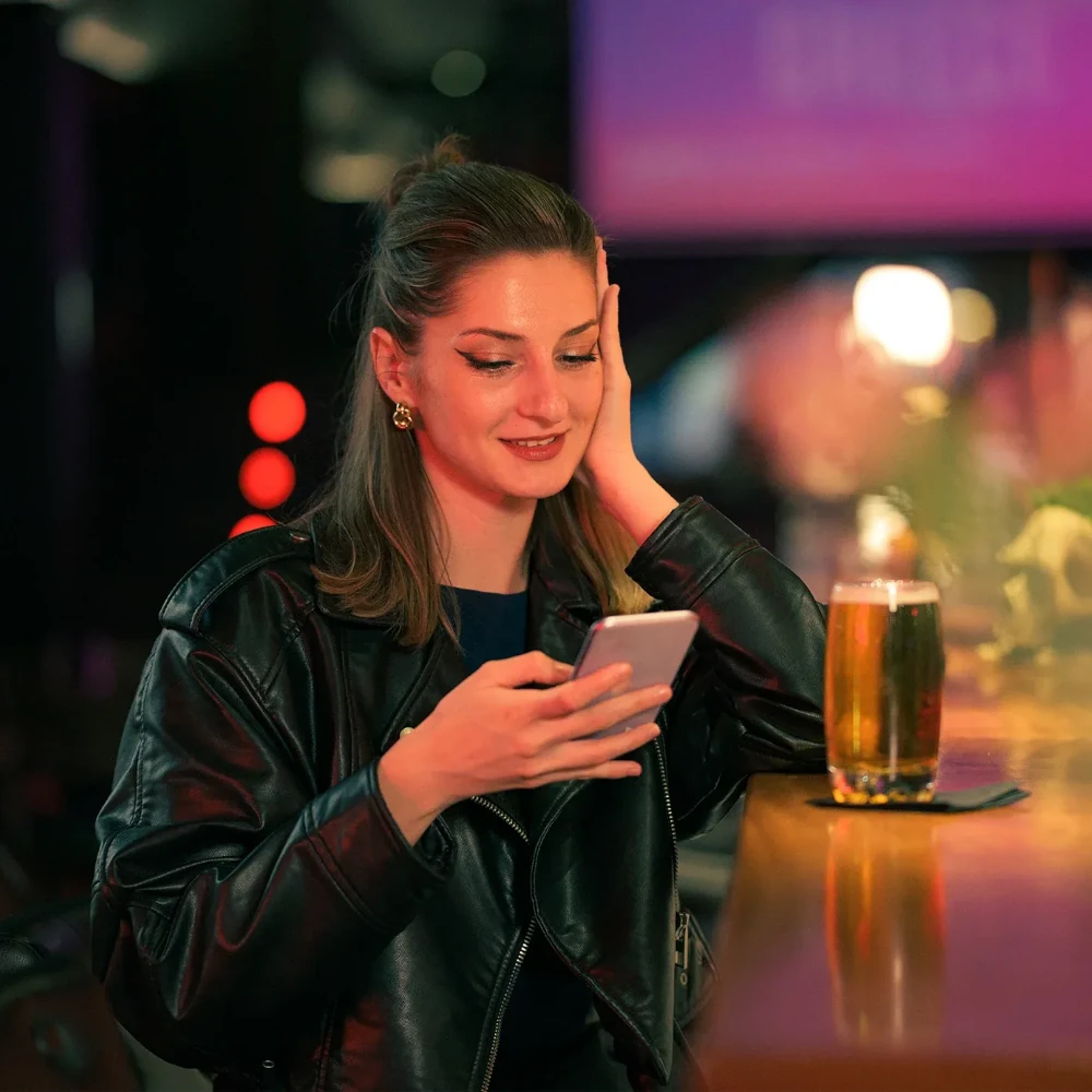 A woman booking tickets for a nightclub event on her mobile phone