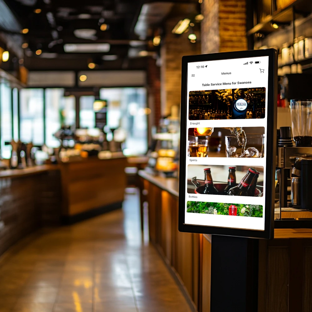 A digital sign on a stand outside a coffee shop