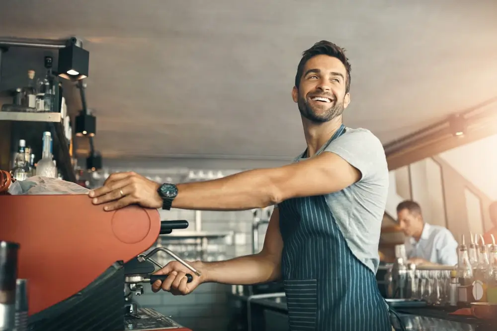 Smiling Barista with coffee machine