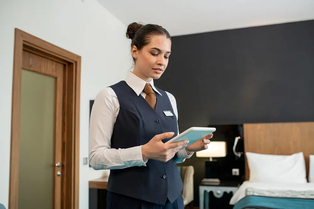 young hotel worker uniform using tablet bedroom