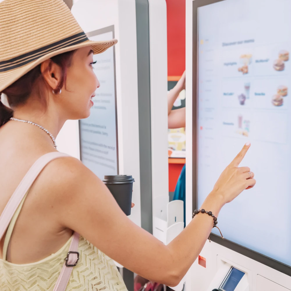 A woman ordering food from a self-service kiosk at a festival
