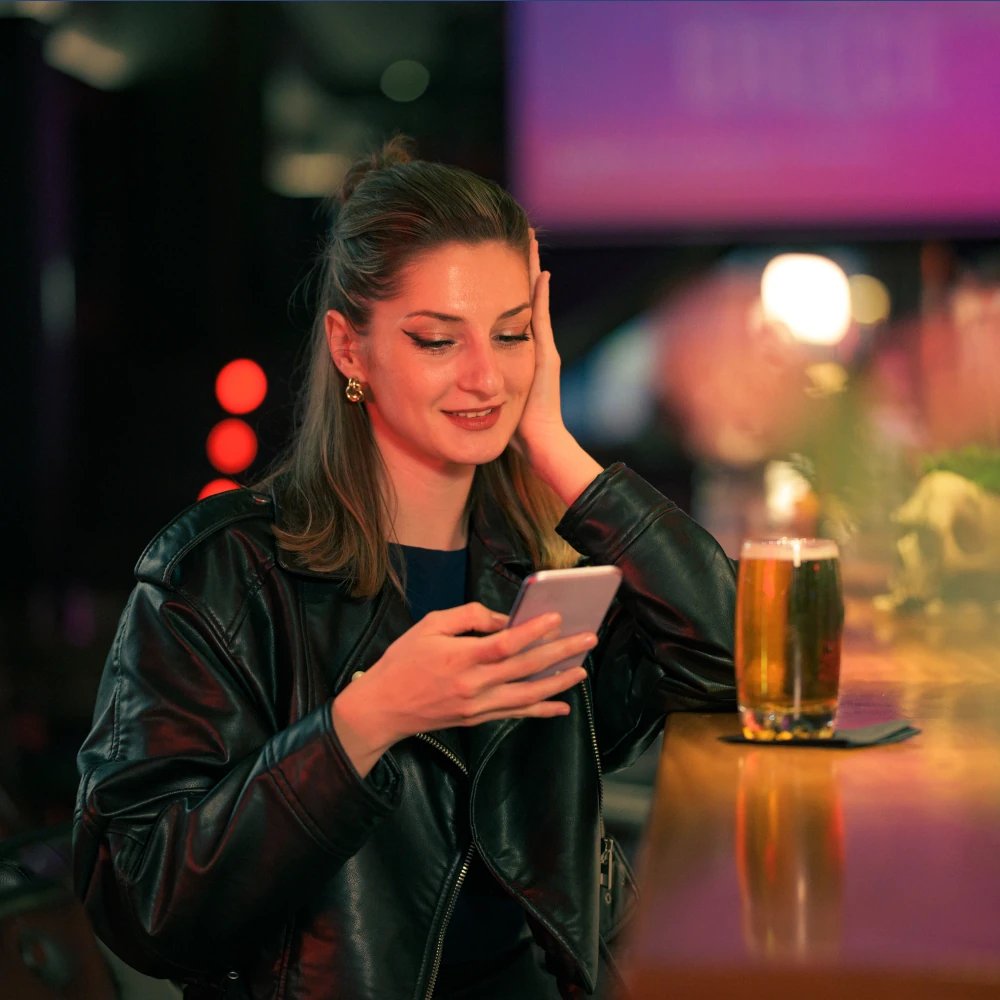 A woman checking her phone in a nightclub